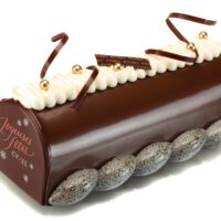 Bizcocho “pain d’épices” y chocolate, cremoso perfumado con vainilla natural, bavaroise perfumada con vainilla natural, crujiente de praliné de avellana, mousse de chocolate, glaseado de chocolate.
Sugerencia del Chef, sacar del refrigerador una hora y media antes de servir.